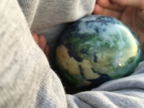 Small earth being held
